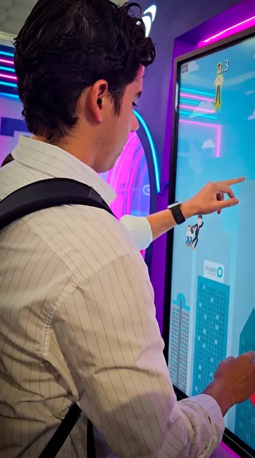 Usuario interactuando con un juego en una pantalla touch gigante